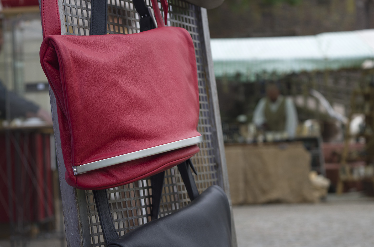 Olbrish handbag Wandelbar in burgundy hangs on a grid at a crafts market