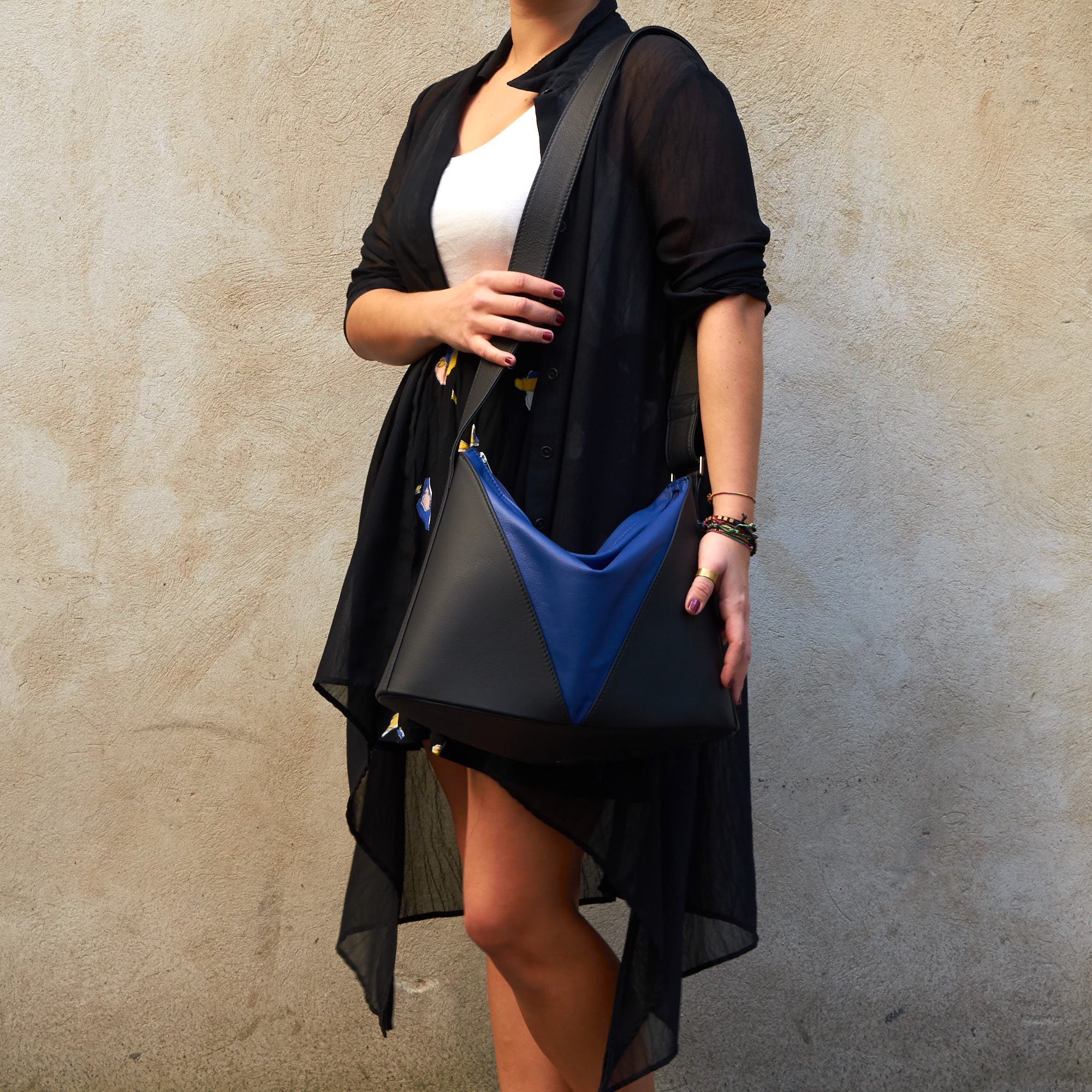 Frau trägt Olbrish Handtasche Akkordeon aus schwarz-royalblauem Nappaleder