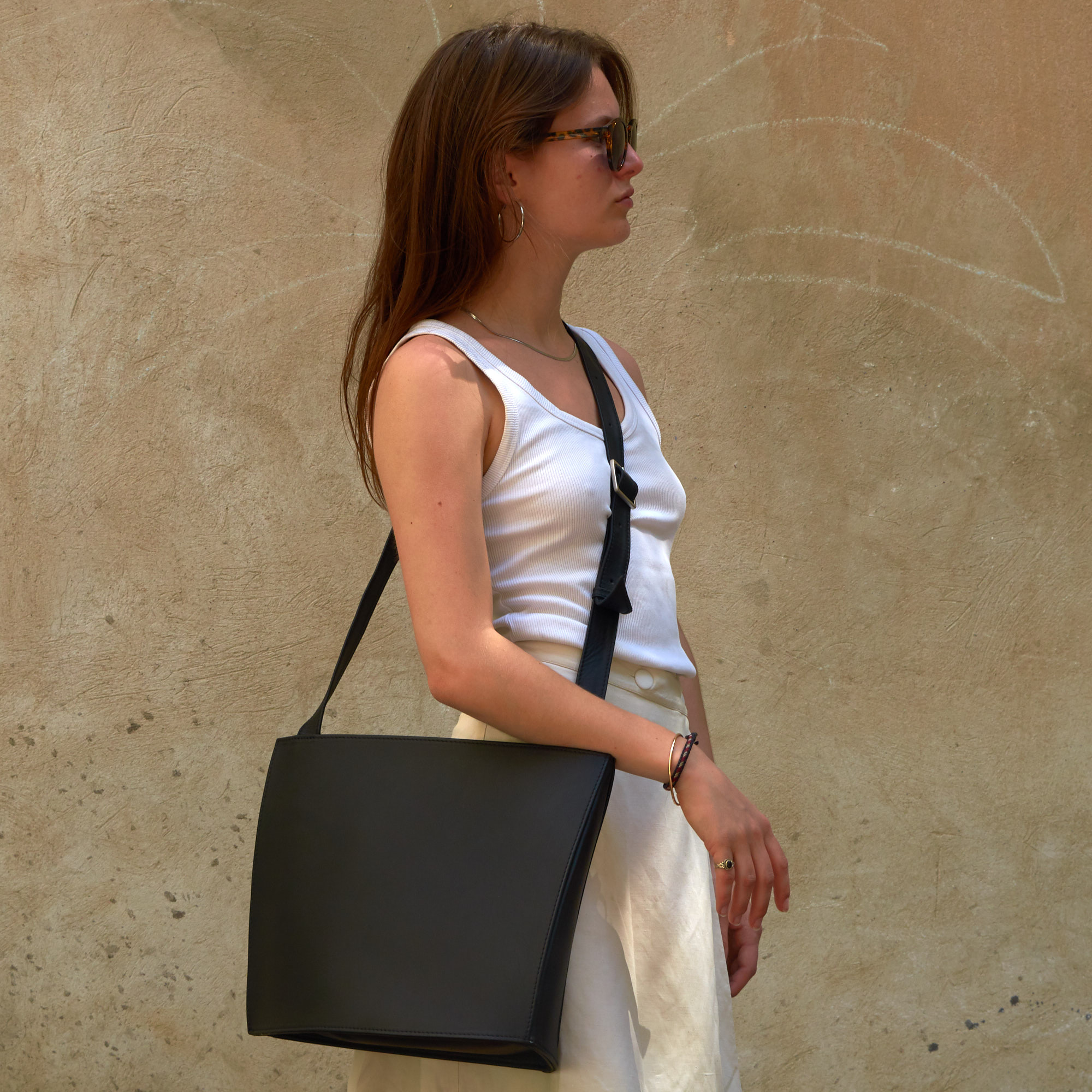 Frau trägt Olbrish Handtasche Vela, Größe L, aus schwarz-rotem Nappaleder