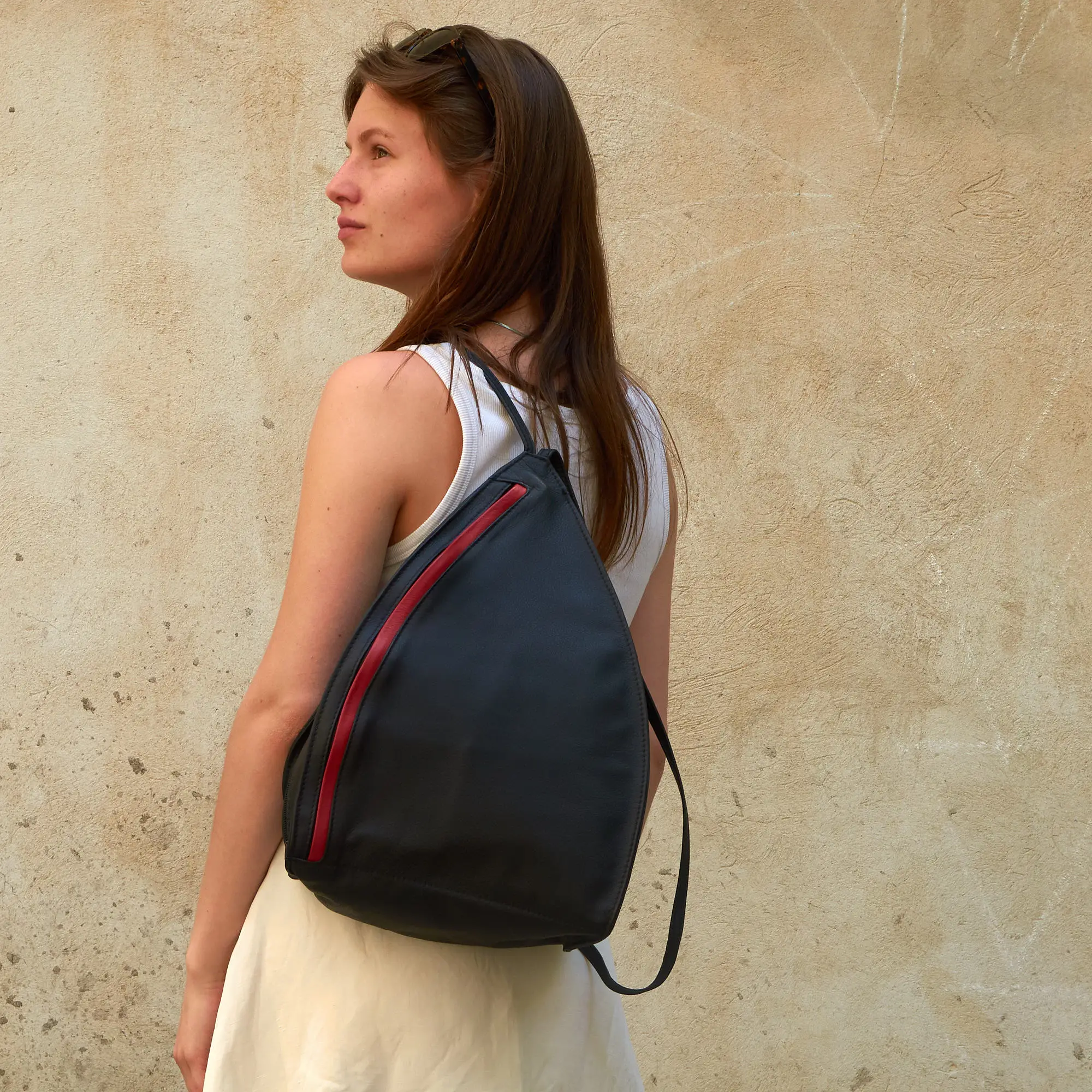 Frau trägt Olbrish Rucksack Lenz, in der Größe L, aus schwarz-rotem Nappaleder