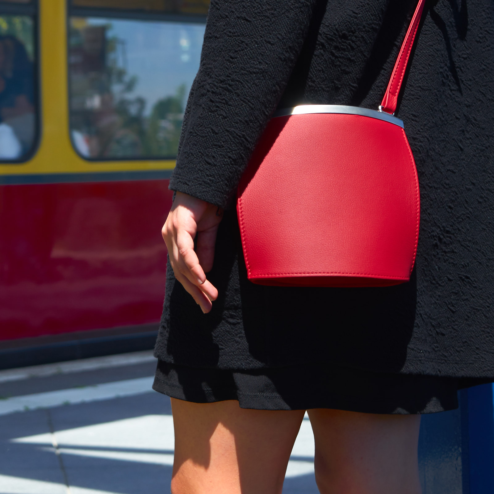 Woman wears Olbrish handbag Arcade in red nappa leather at an S-Bahn station in Berlin