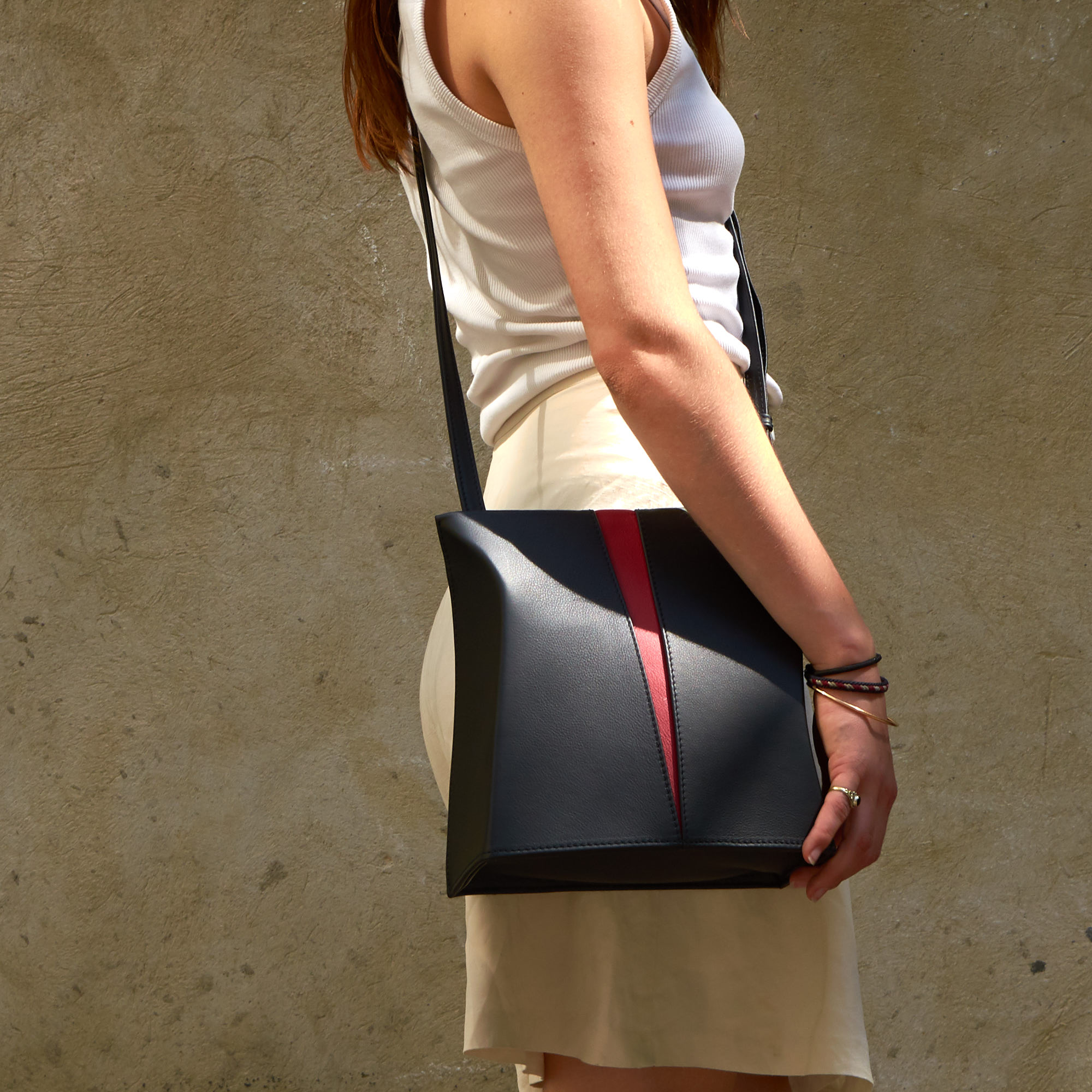 Frau trägt Olbrish Handtasche Tango, aus schwarz-rotem Nappaleder