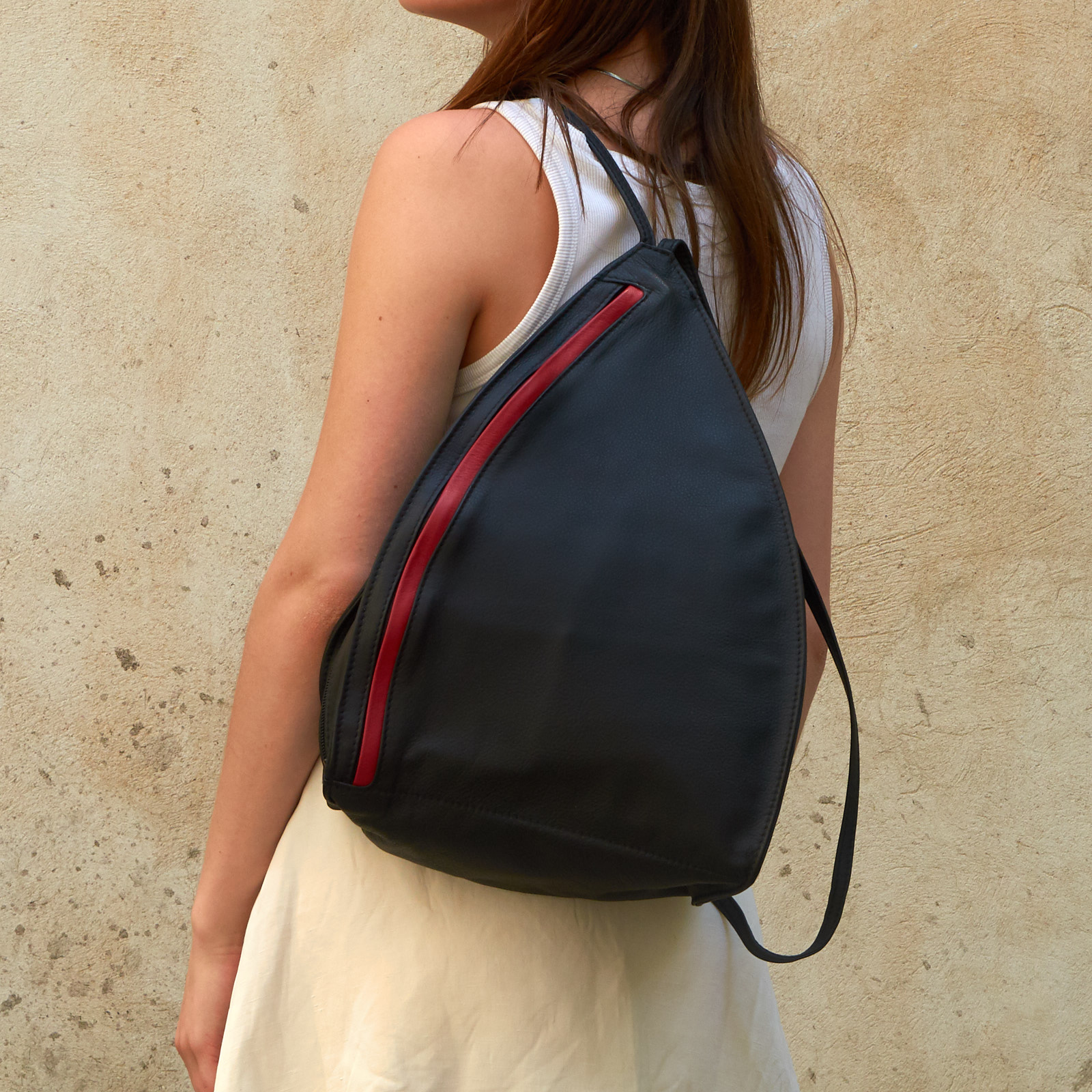 Woman wears Olbrish backpack Lenz in black and red nappa leather, size M, on her shoulder