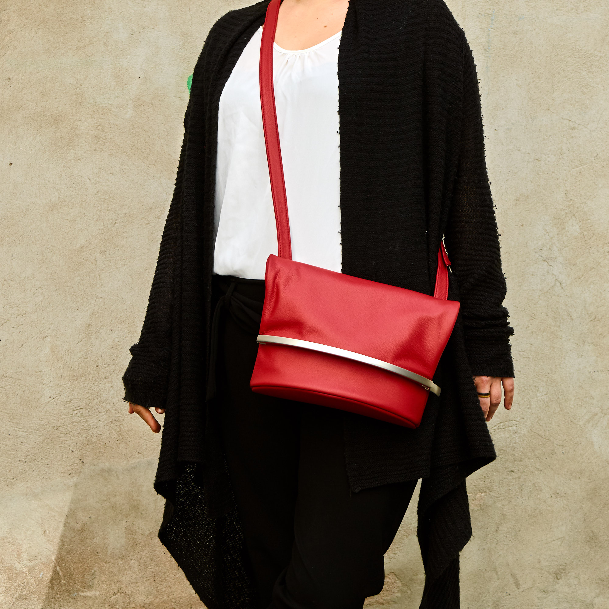 Frau trägt Olbrish Handtasche Wandelbar, Größe M, aus rotem Nappaleder