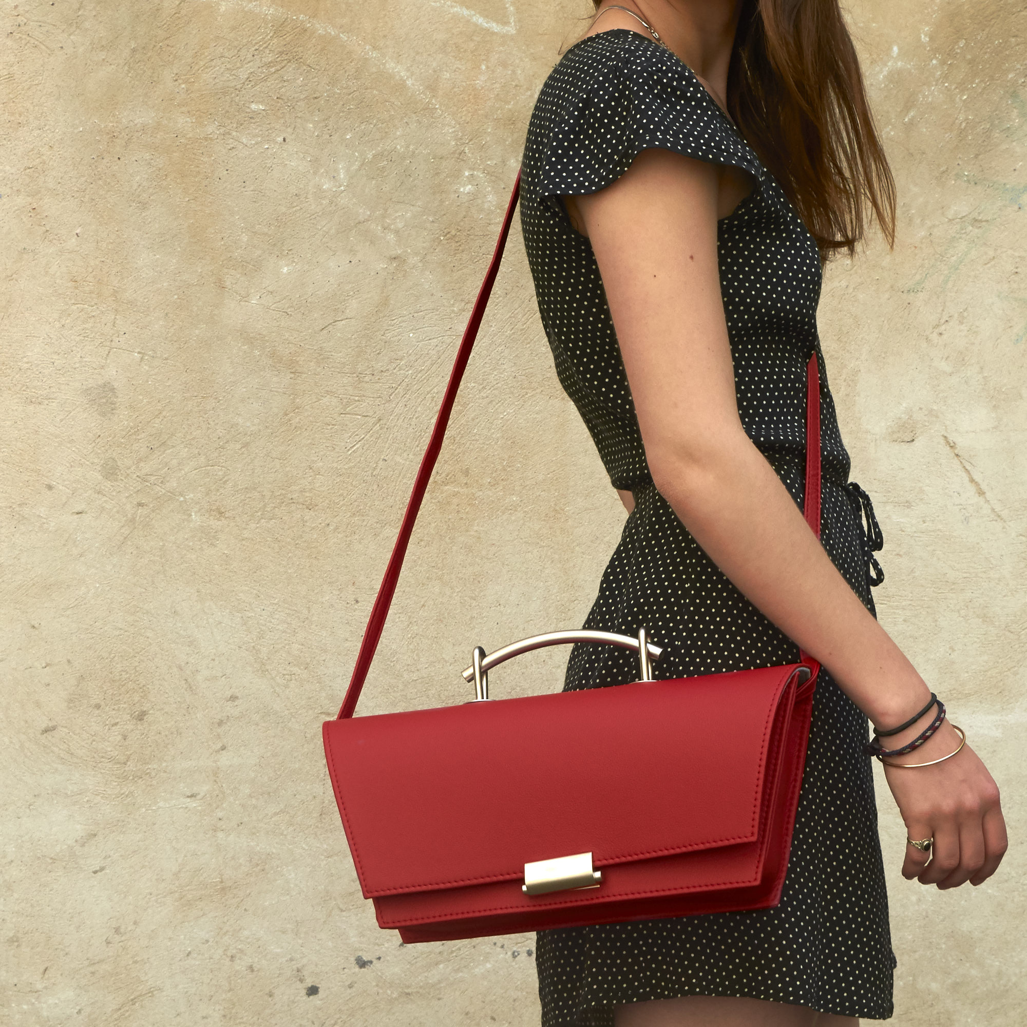 Frau trägt Olbrish Handtasche Torii, Größe L, aus rotem Nappaleder, auf der Schulter