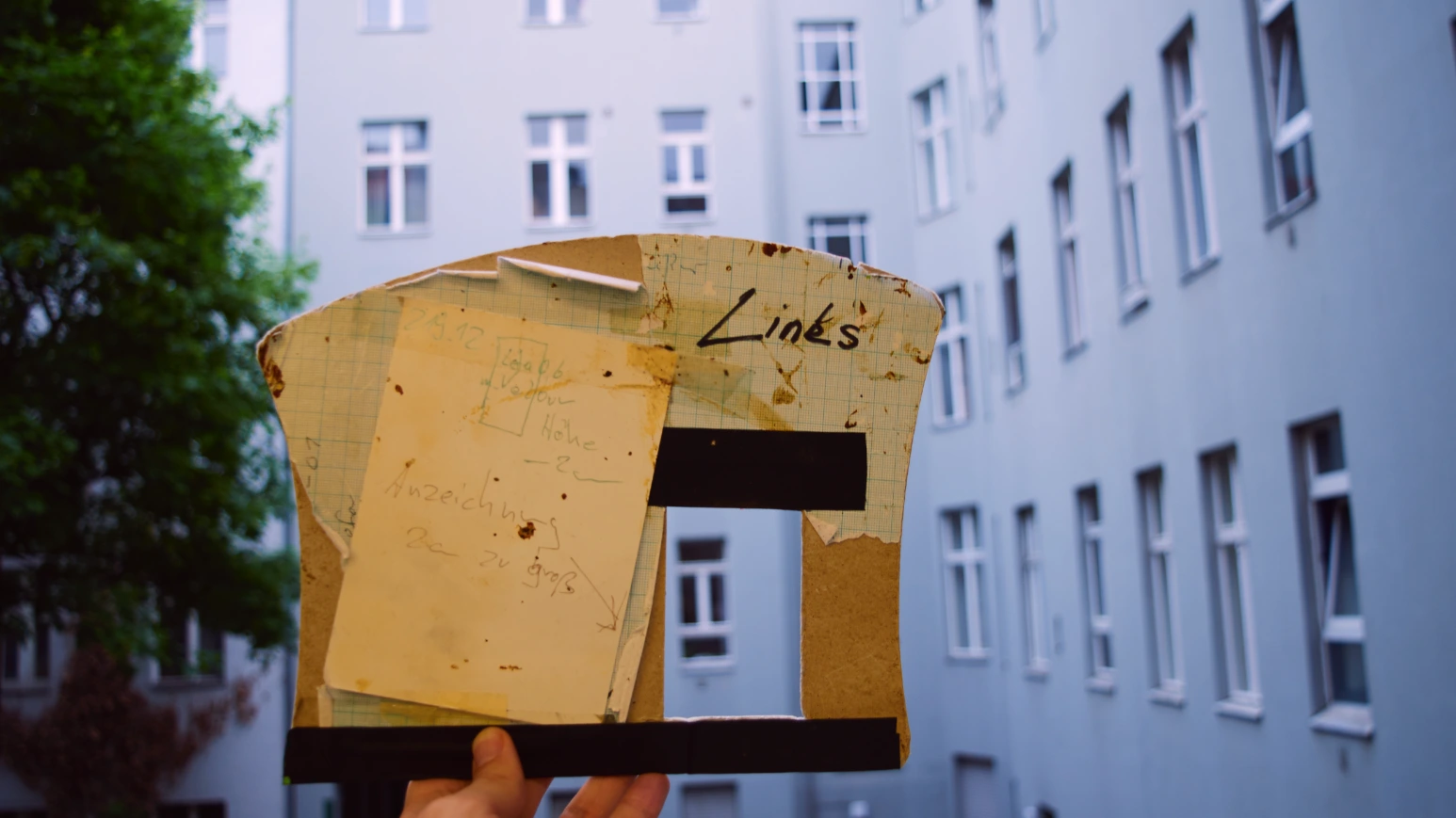 Eine Hand hält eine Schneideschablone von einer Olbrish-Handtasche