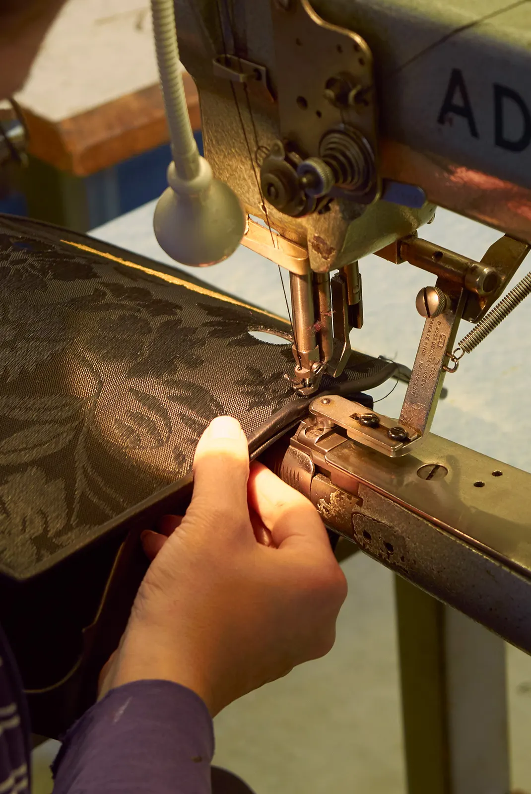 Eine Frau näht eine Olbrish-Ledertasche an der Nähmaschine, Detailansicht